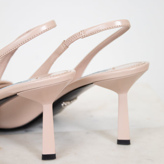 Pair of beige high-heeled sandals on a light gray background