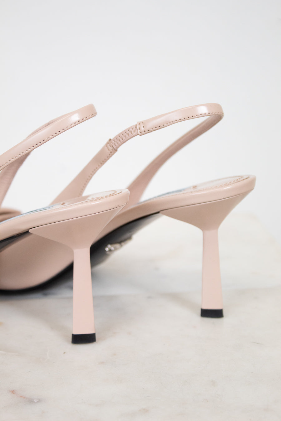 Pair of beige high-heeled sandals on a light gray background