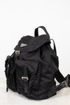 Side view of black nylon 'PRADA' backpack against a plain background