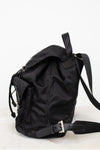 Side view of black nylon backpack against a plain background
