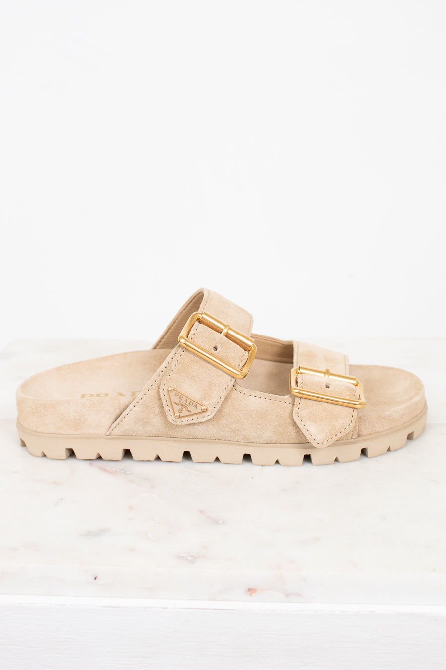 Beige sandal with gold buckles on a white background