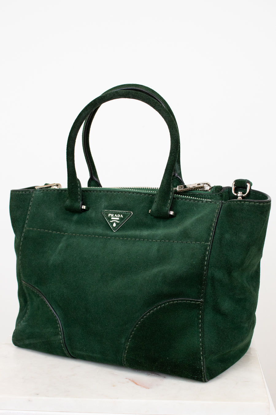 Green handbag with Prada logo on a white background