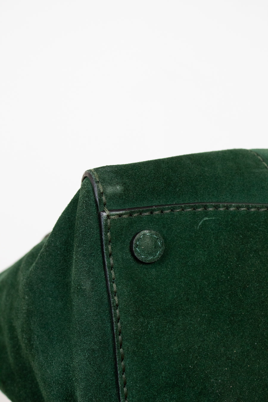 Close-up of a green purse with a button on a white background