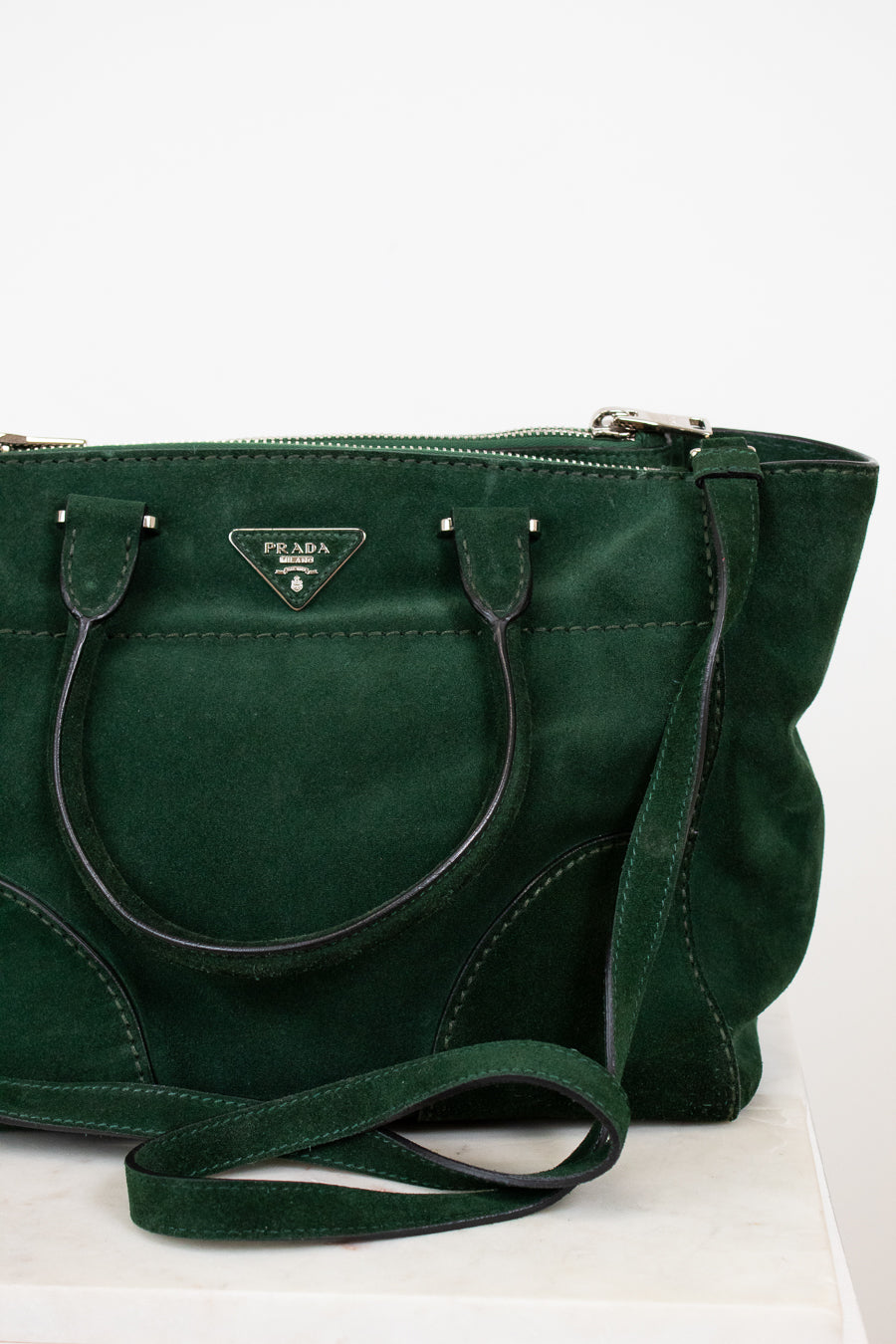 Green handbag with Prada logo on a white background