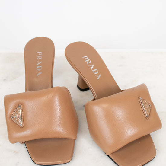 Pair of Prada tan sandals on a white background