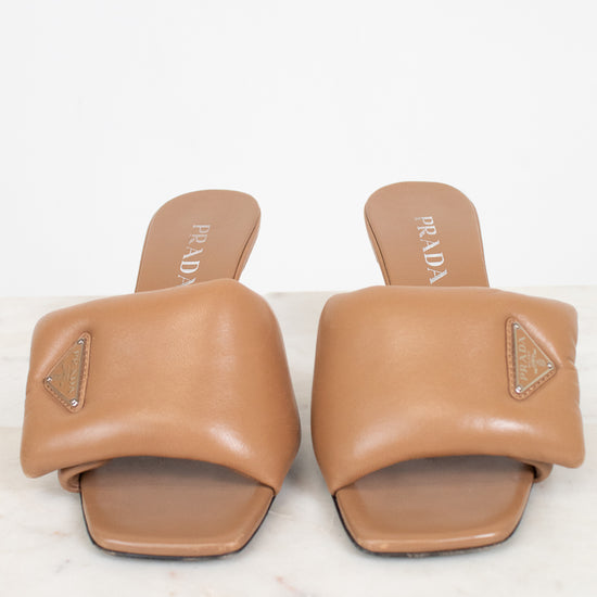 Pair of tan Prada sandals on a white background