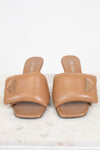 Pair of tan Prada sandals on a white background