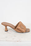 Tan high-heeled sandal with Prada logo on a white marble surface