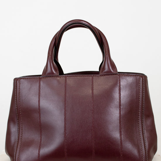 Maroon leather handbag on a light background