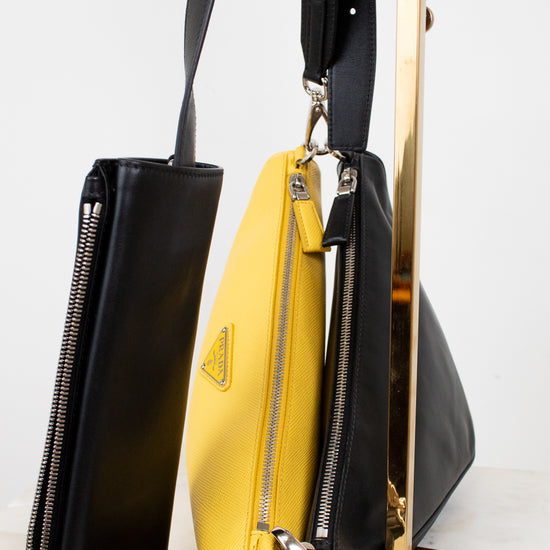 Black and yellow handbag with Prada logo on a white background