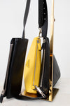 Black and yellow handbag with Prada logo on a white background