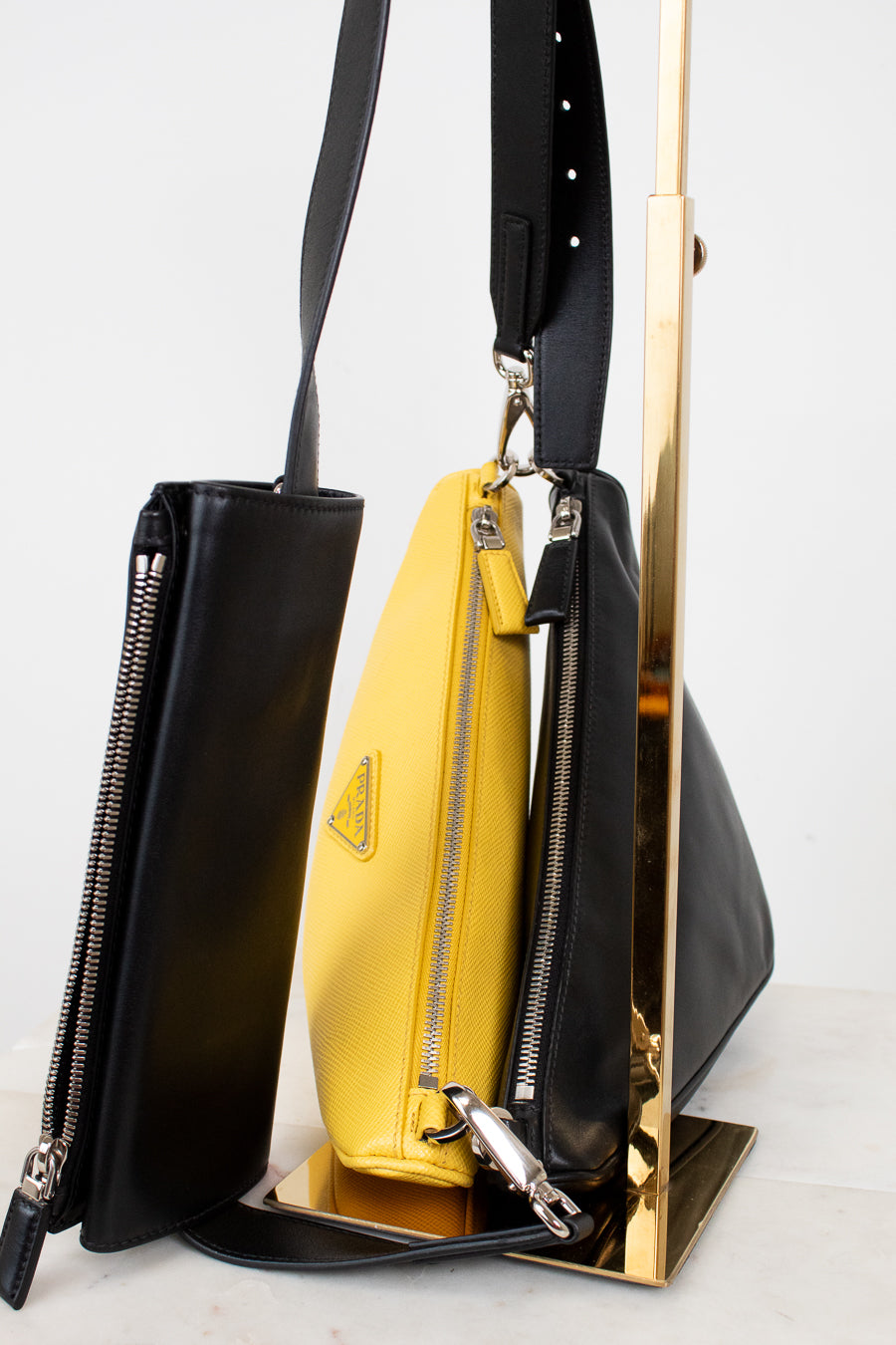 Black and yellow handbag with Prada logo on a white background