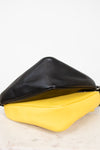Black and yellow handbag on a white surface
