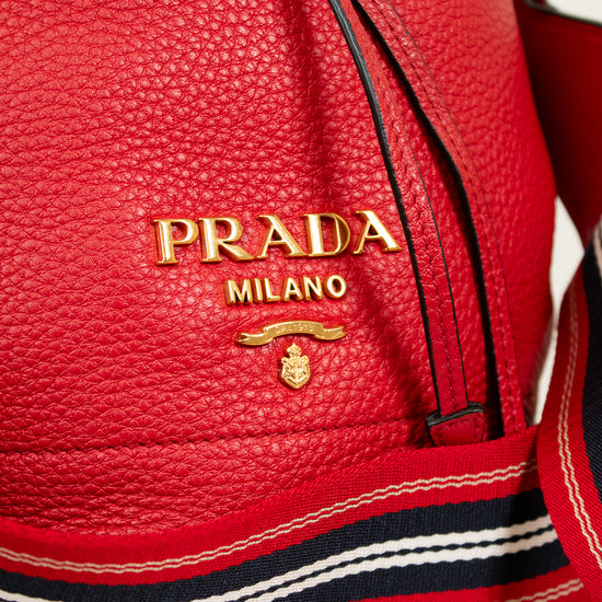 Red Prada handbag with gold logo on a light background
