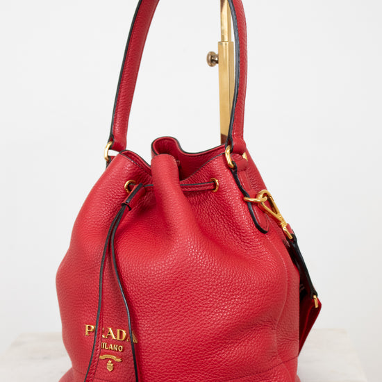 Red leather handbag with gold accents on a white background