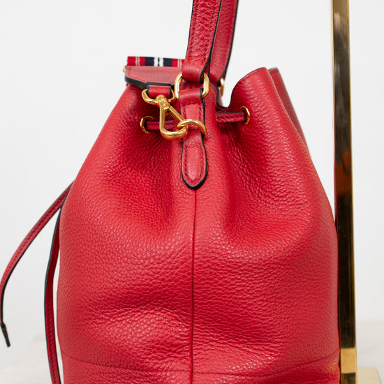 Red leather bucket bag with gold clasp on a white background