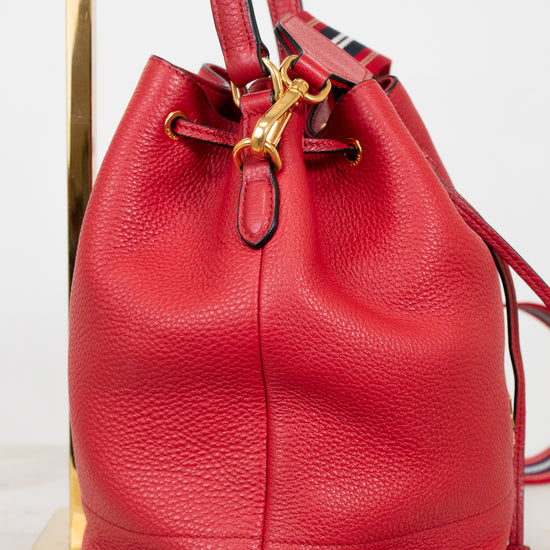 Red leather bucket bag with gold clasp on a white background