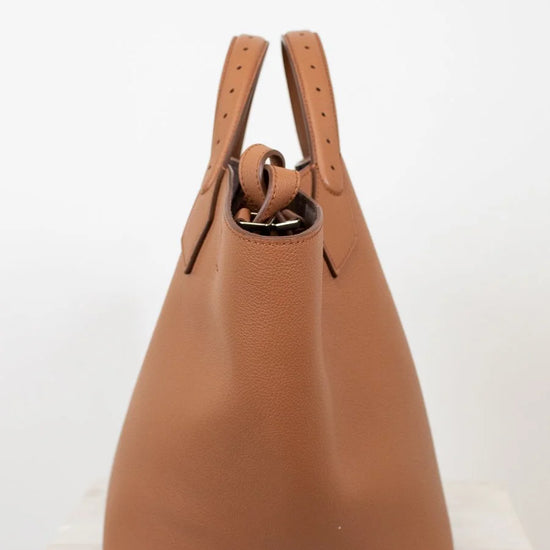 Brown leather handbag with handles on a white background