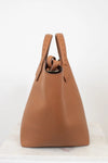 Brown leather handbag with handles on a white background