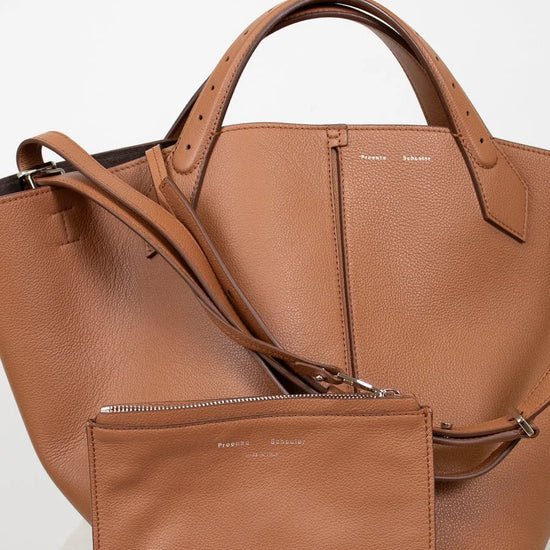Brown leather handbag with matching pouch on a white background