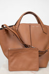 Brown leather handbag with matching pouch on a white background