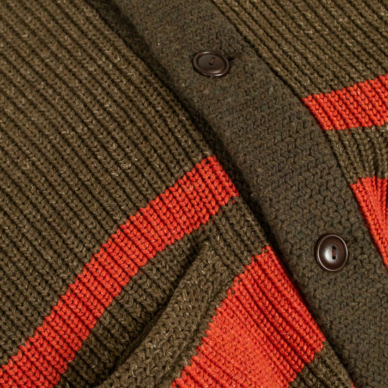 Close-up of a green and orange striped cardigan with buttons.