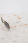 Aviator sunglasses with gold frame on a marble surface
