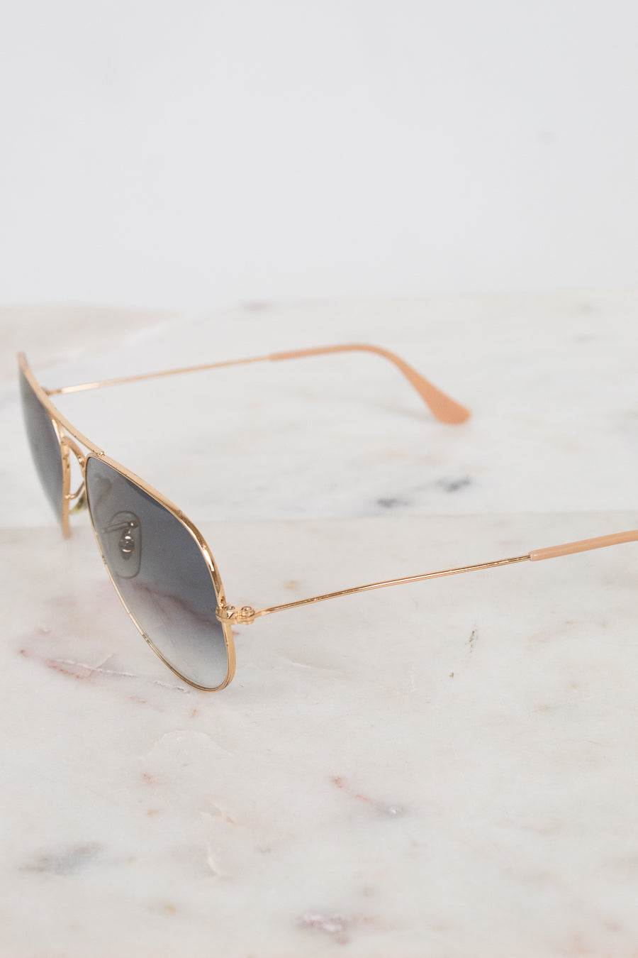 Aviator sunglasses with gold frame on a marble surface