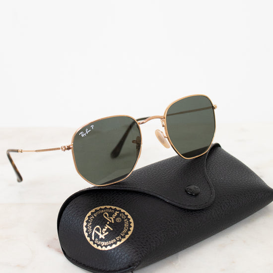 Sunglasses with a black case on a light marble background