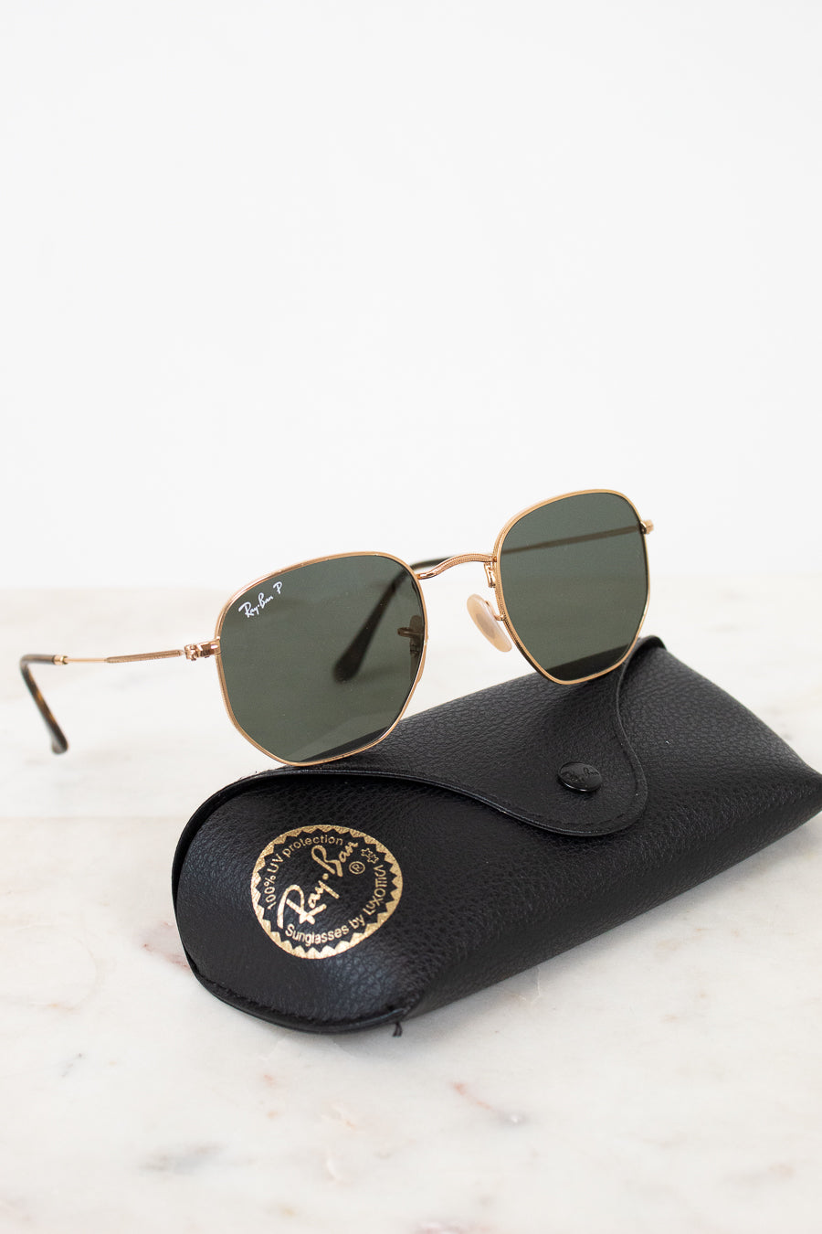 Sunglasses with a black case on a light marble background