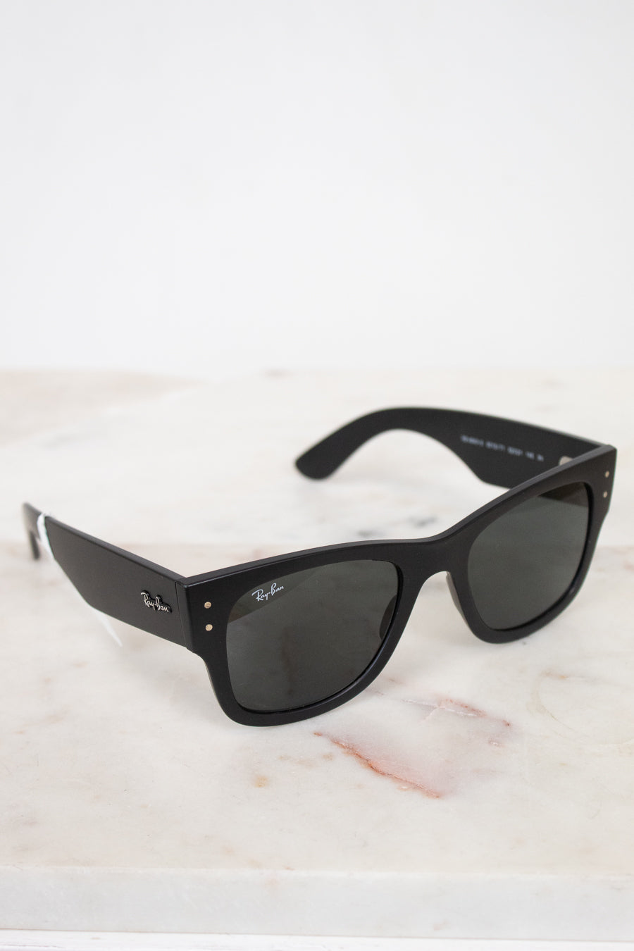 Black sunglasses on a light marble surface