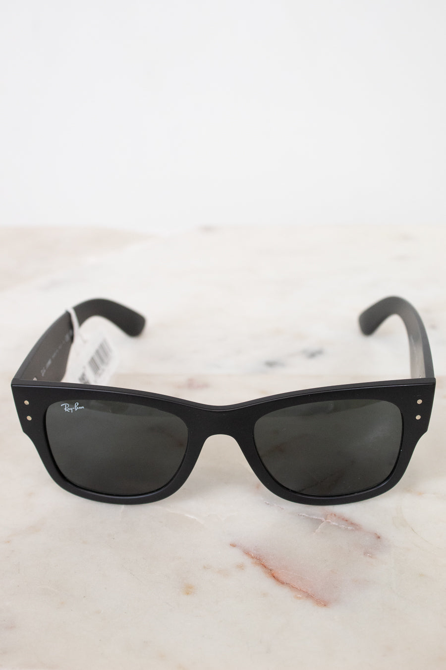 Black sunglasses on a white marble surface