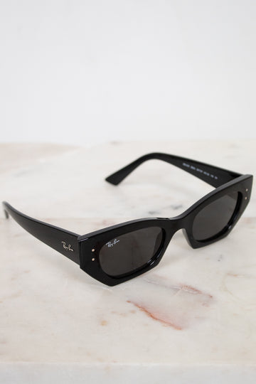 Black sunglasses with a Ray-Ban logo on a marble surface