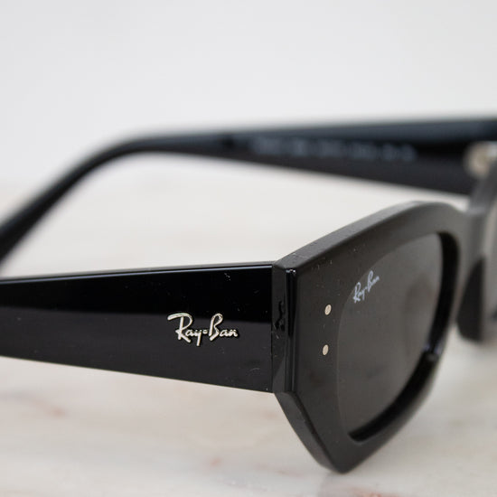 Black Ray-Ban sunglasses on a marble surface with a white background