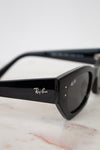 Black Ray-Ban sunglasses on a marble surface with a white background