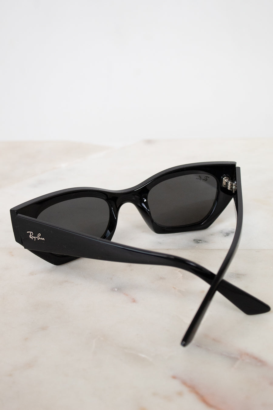 Black cat-eye sunglasses on a marble surface