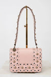 Pink handbag with decorative studs on a white background