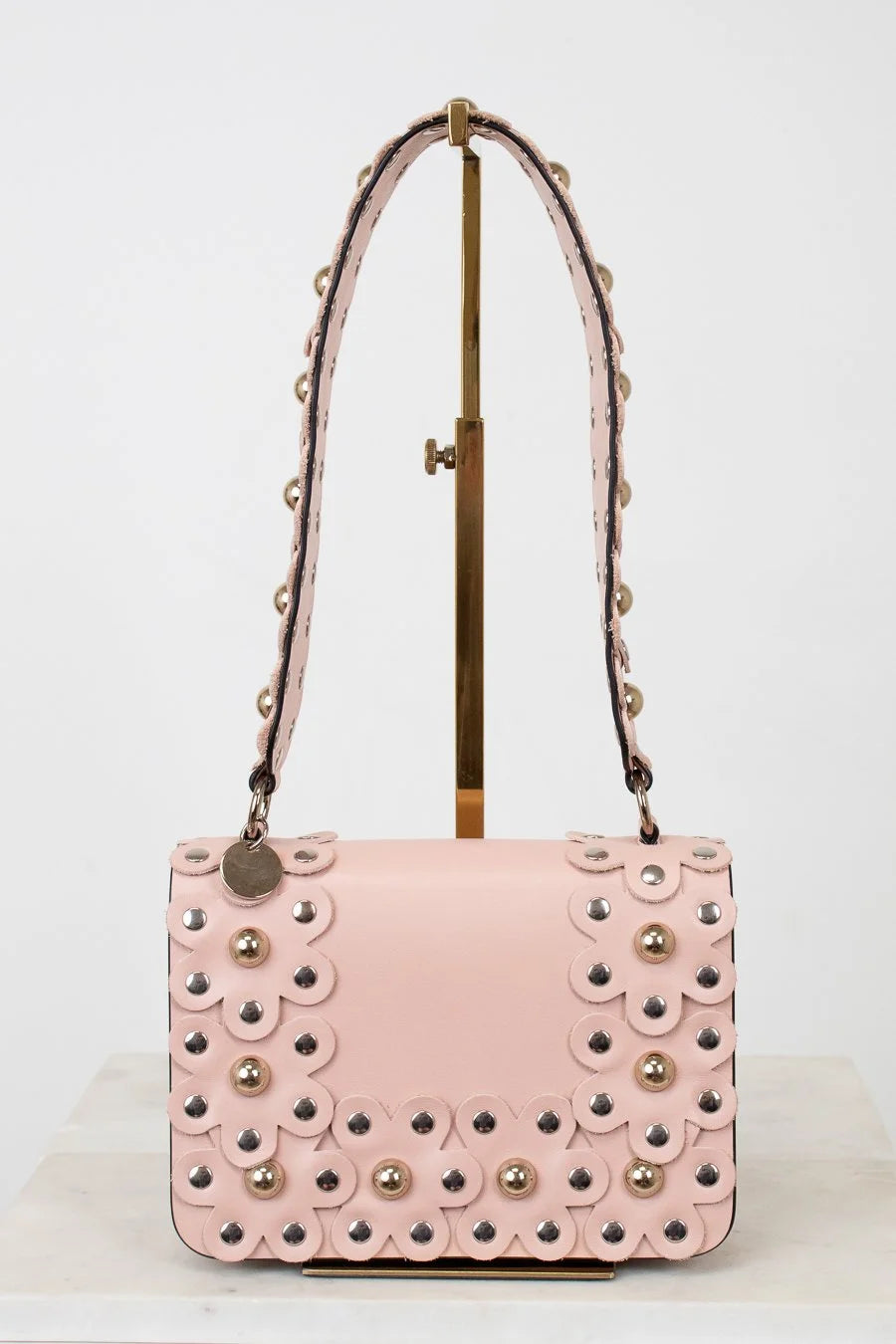 Pink handbag with decorative studs on a white background