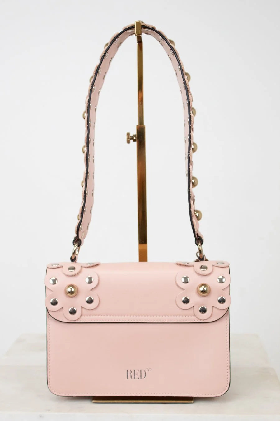 Pink handbag with gold studs on a white background