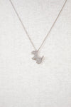 Silver necklace with a dog-shaped pendant on a light gray textured background