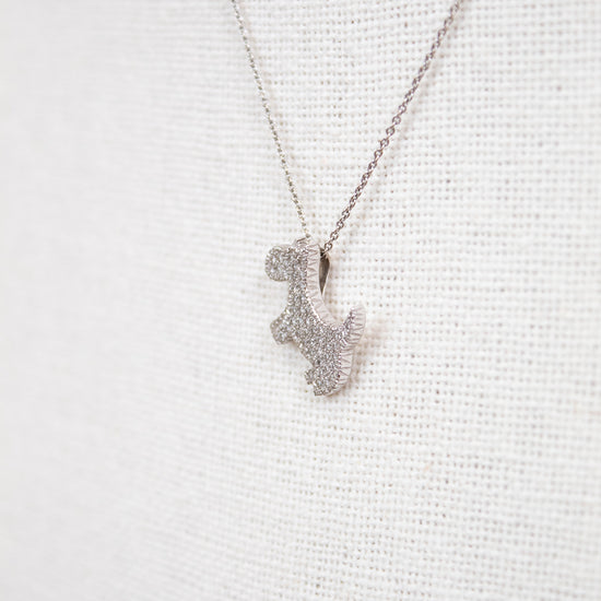 Silver necklace with a small pendant on a light gray background