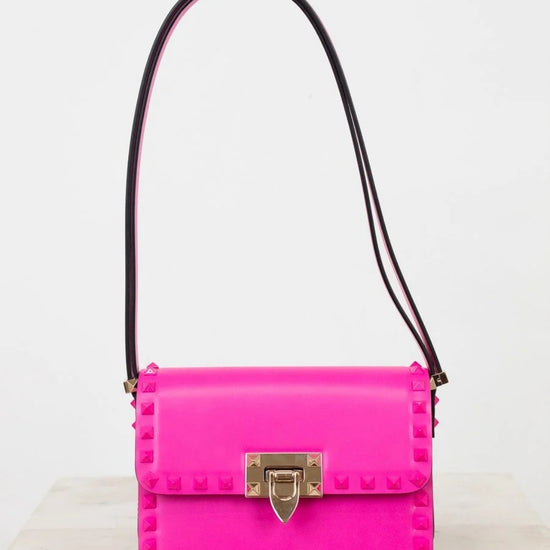 Pink handbag with a gold clasp on a white background