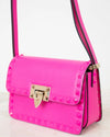 Pink handbag with gold accents on a light background