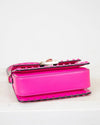 Pink handbag with studded details on a light gray background