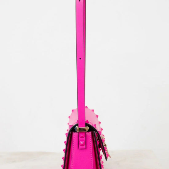 Pink handbag with a strap on a white background