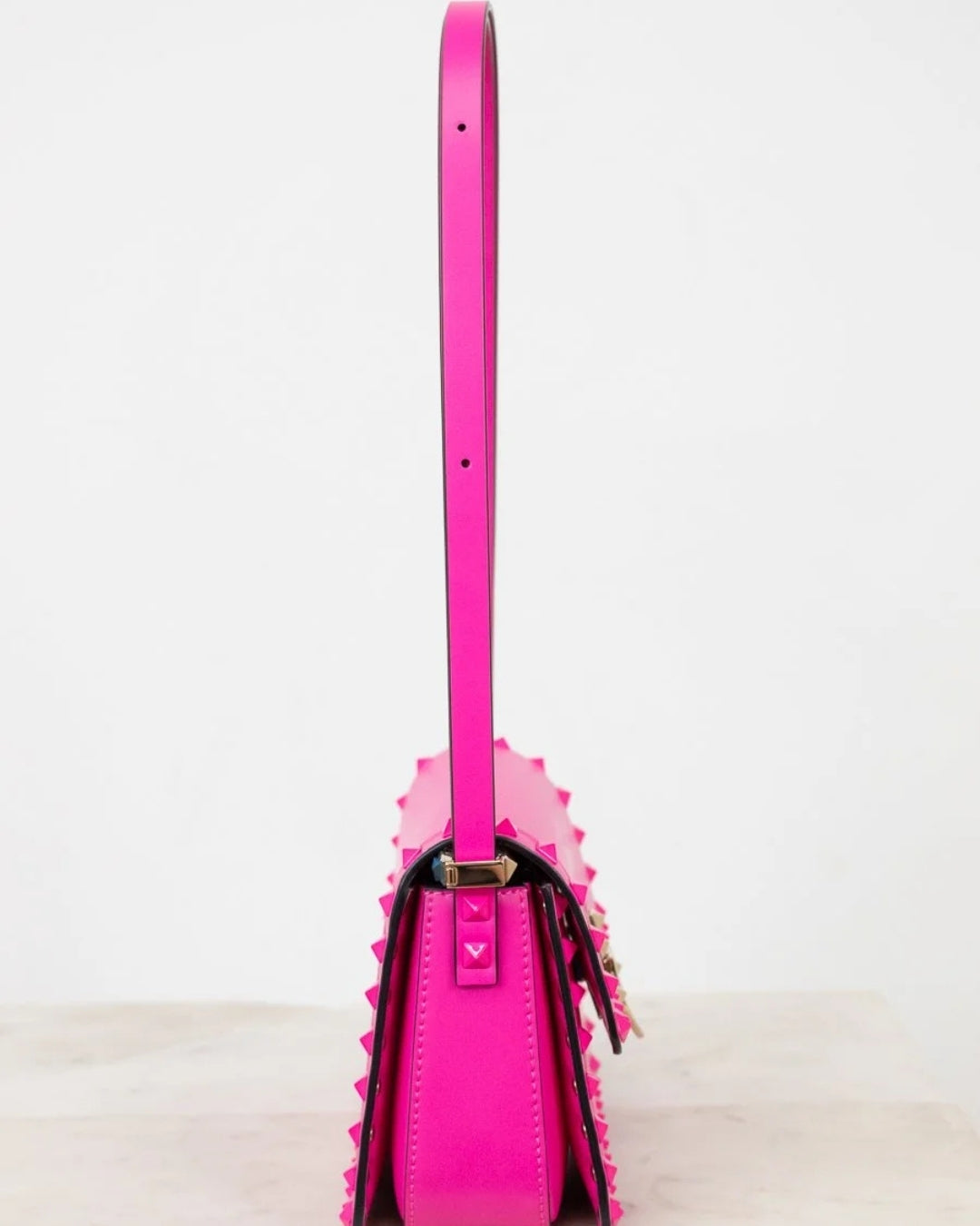 Pink handbag with a strap on a white background