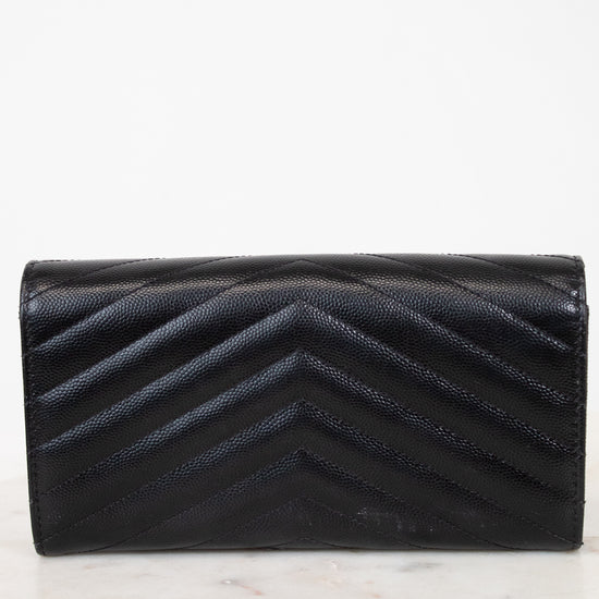 Black quilted wallet on a light marble background