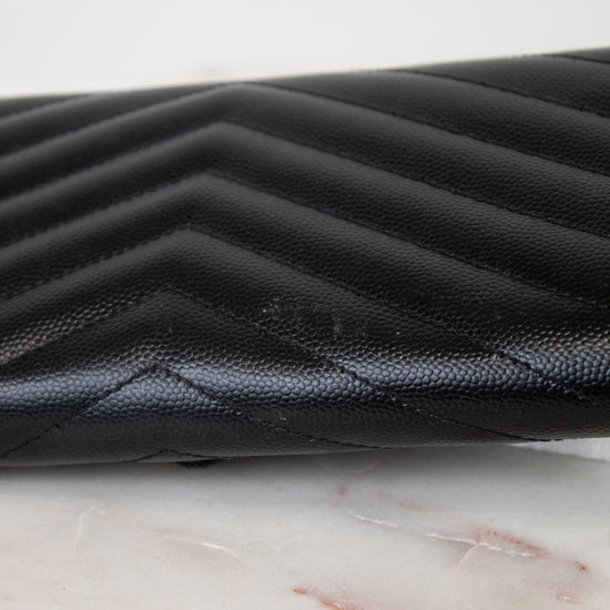 Black quilted leather wallet on a marble surface