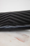 Black quilted leather wallet on a marble surface