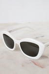White sunglasses with dark lenses on a marble surface